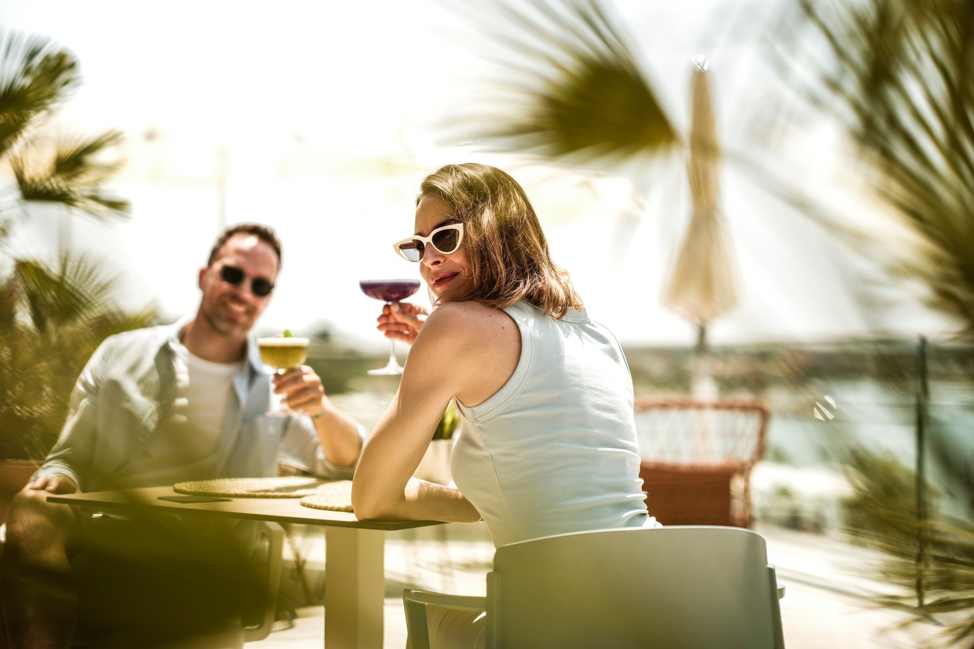 Couple enjoying drinks on a sunny terrace at Zaton Holiday Resort with sea view Zaton Holiday Resort