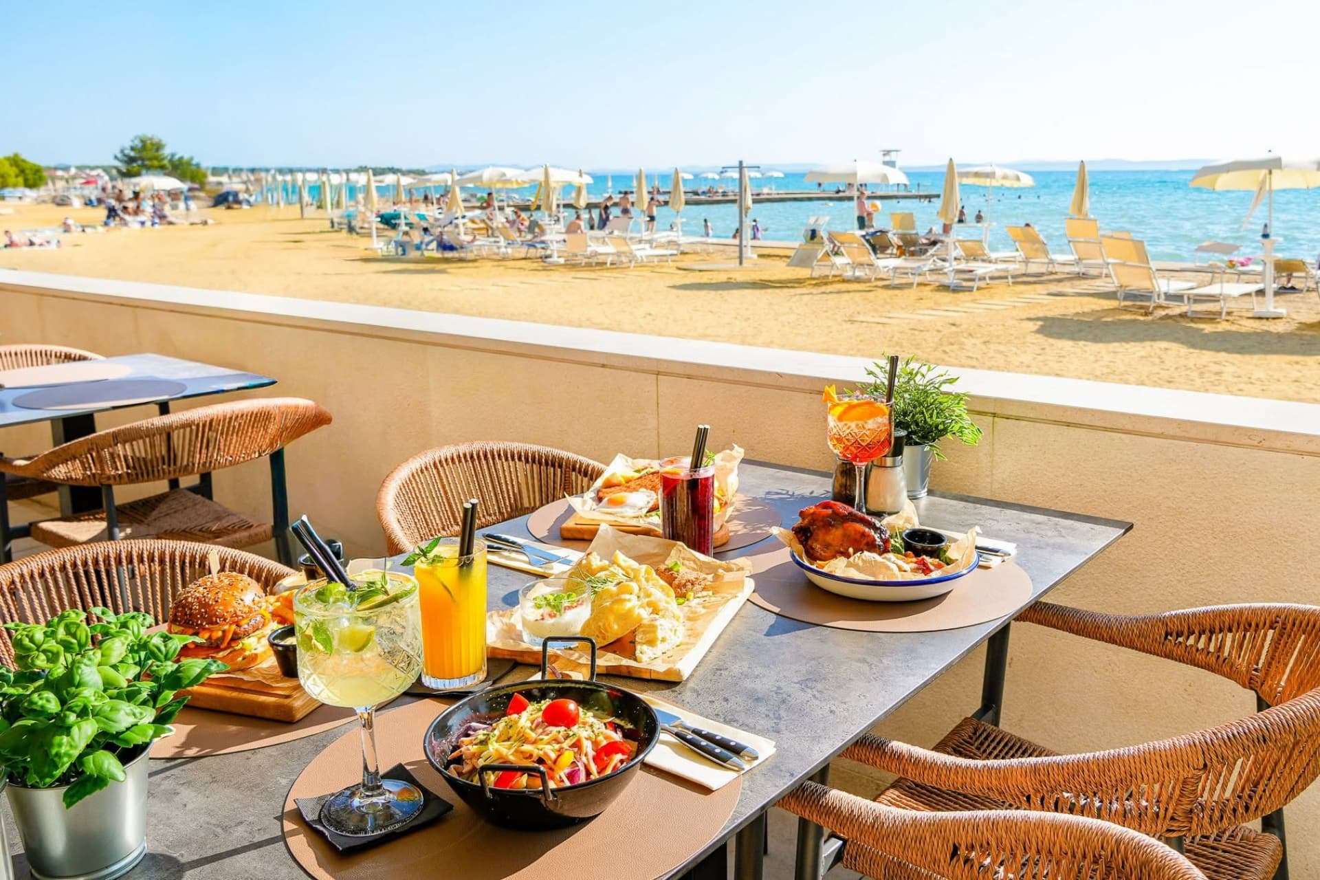 Posiłek przy plaży w Maestral Restaurant & Pub Posiłek przy plaży w Maestral Restaurant & Pub, obejmujący swobodne dania i orzeźwiające napoje, z widokiem na Morze Adriatyckie