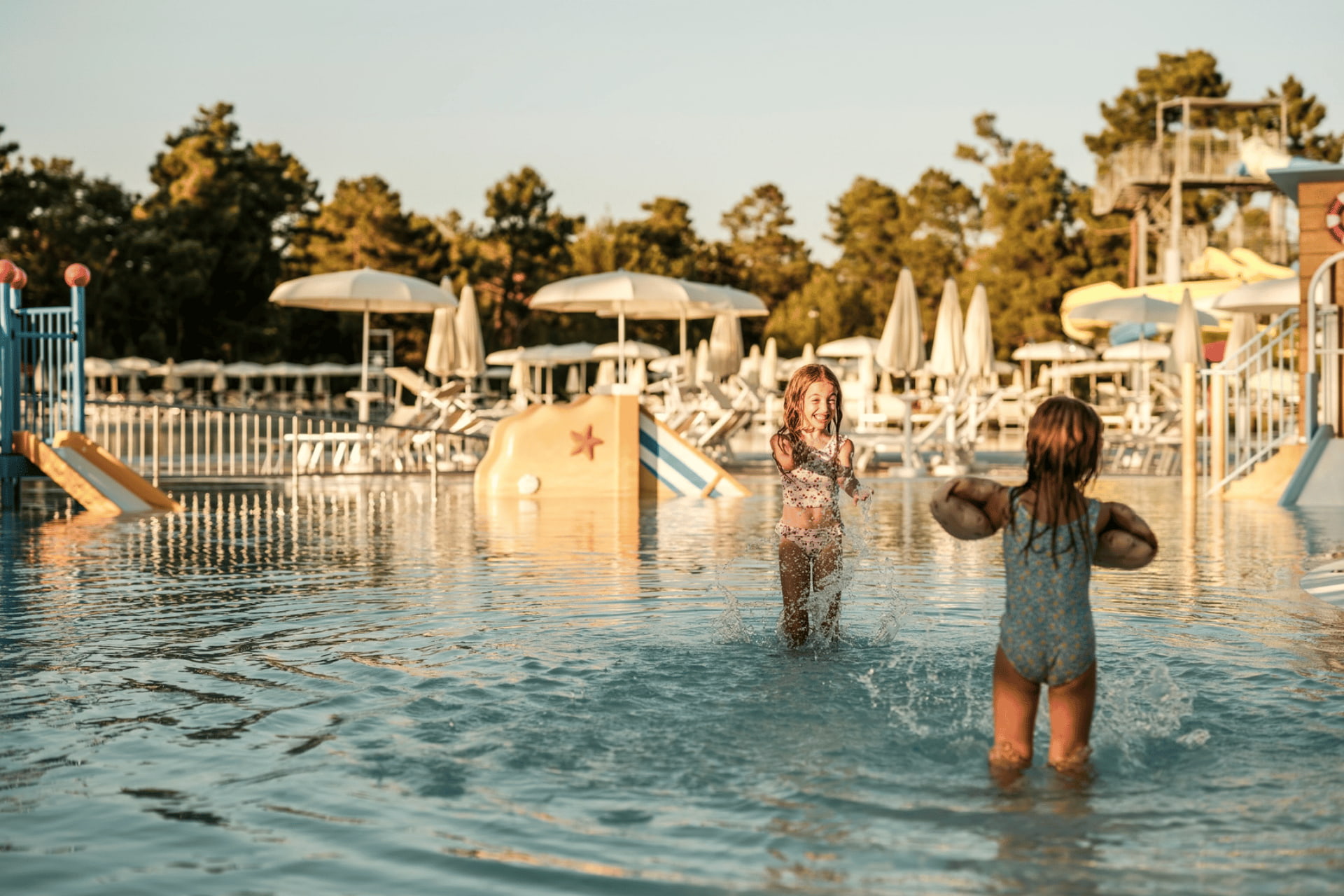 Kinder spielen in einem Pool mit Wasserrutschen Kinder spielen in einem Pool mit Wasserrutschen im Zaton Holiday Resort in Kroatien