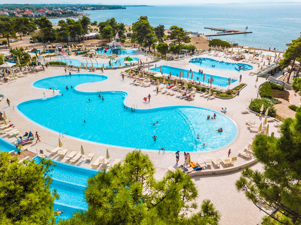 Laufen Sie zwischen dem Strand und den Swimmingpools hin und her